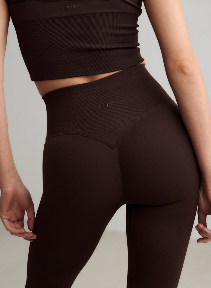 Close-up from behind of a model wearing aim'n's chocolate Shape Seamless Tall Tights, showing the scrunch detail. [S-174cm]