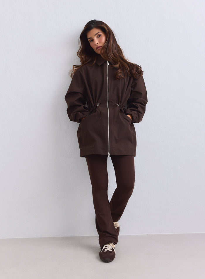 Chocolate aim'n Waterproof Zip Jacket with a cinched waist and stand collar, paired with matching brown leggings. [S-165cm]