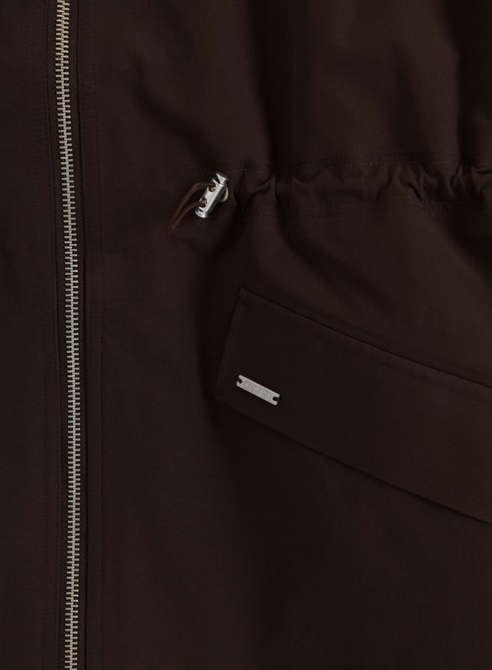 Chocolate Waterproof Zip Jacket detail featuring a silver zipper, logo badge, and adjustable drawstring.