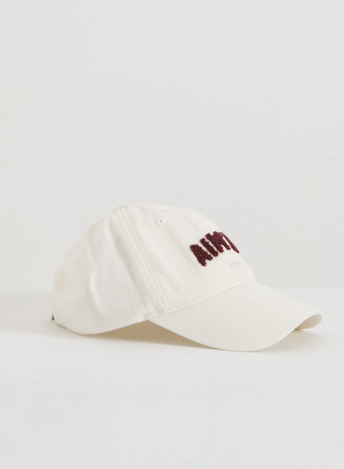 Cream cotton Campus Cap with burgundy embroidered aim'n branding on a white surface.
