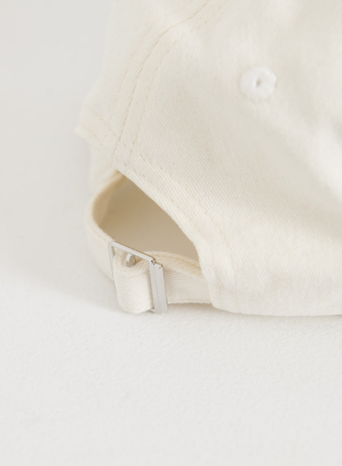 Cream aim'n Campus Cap featuring an adjustable cotton strap with a silver metal buckle.