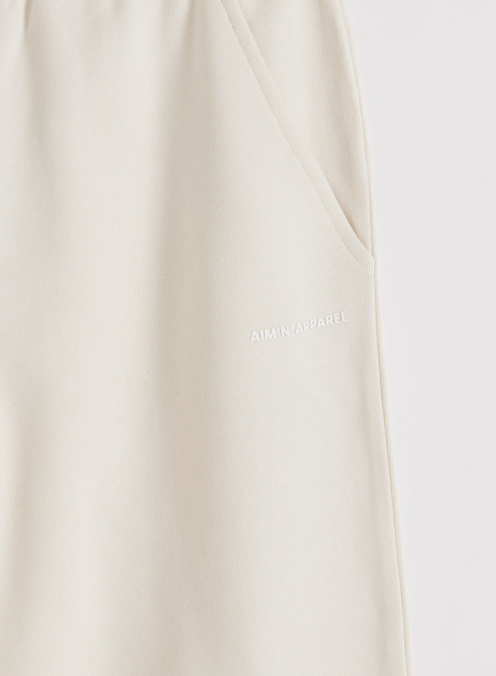 Cream Chunky Terry Sweatpants detail featuring a side pocket and white aim'n logo.