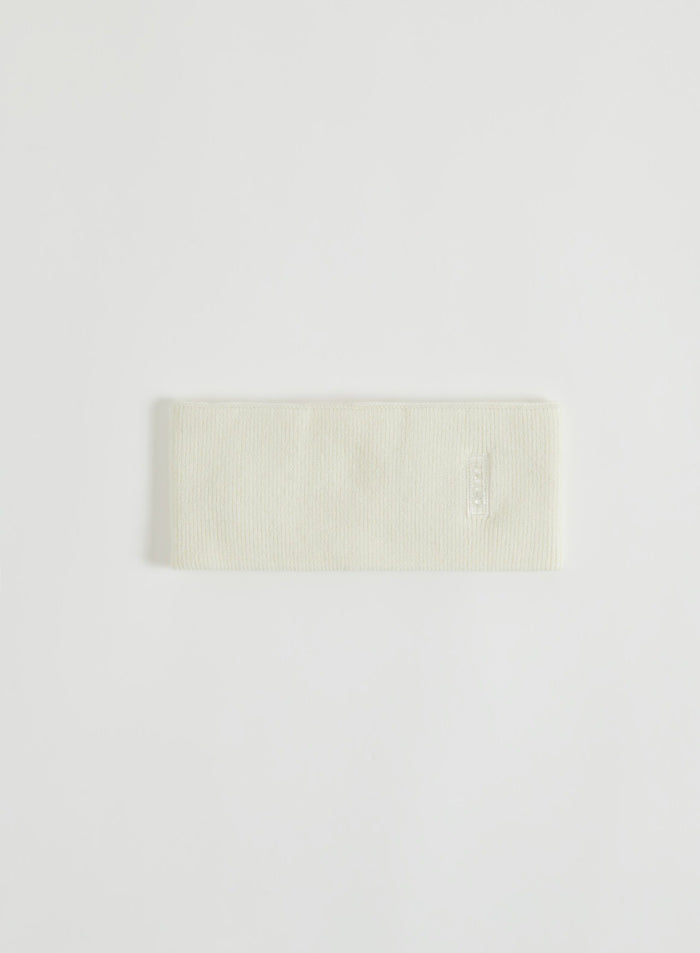 Cream knitted headband with logo detail shown in a flat lay