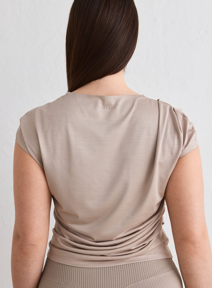 Back view of a woman wearing a Dark Clay Luminous Draped Short Sleeve by aim'n [L-174cm]