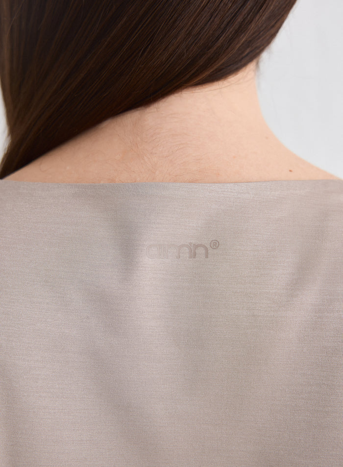 Close-up of the back of the Dark Clay Luminous Draped Short Sleeve featuring the aim'n logo [L-174cm]
