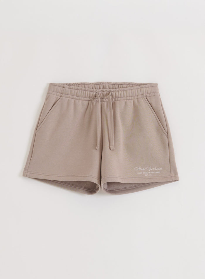 Dark clay Script Sweat Shorts by aim'n with an elastic drawstring waist and side pockets in a flat lay view.