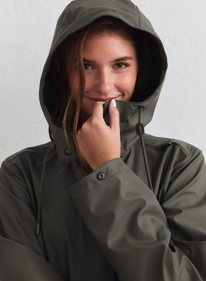Dark ivy aim'n Rain Jacket with an adjustable hood and waterproof finish shown on a model [M-178cm]