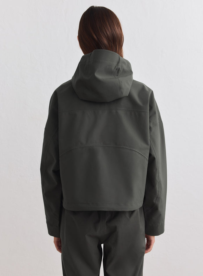 Dark Ivy Waterproof Jacket back view featuring a cropped fit and hood by aim'n. [M-178cm]