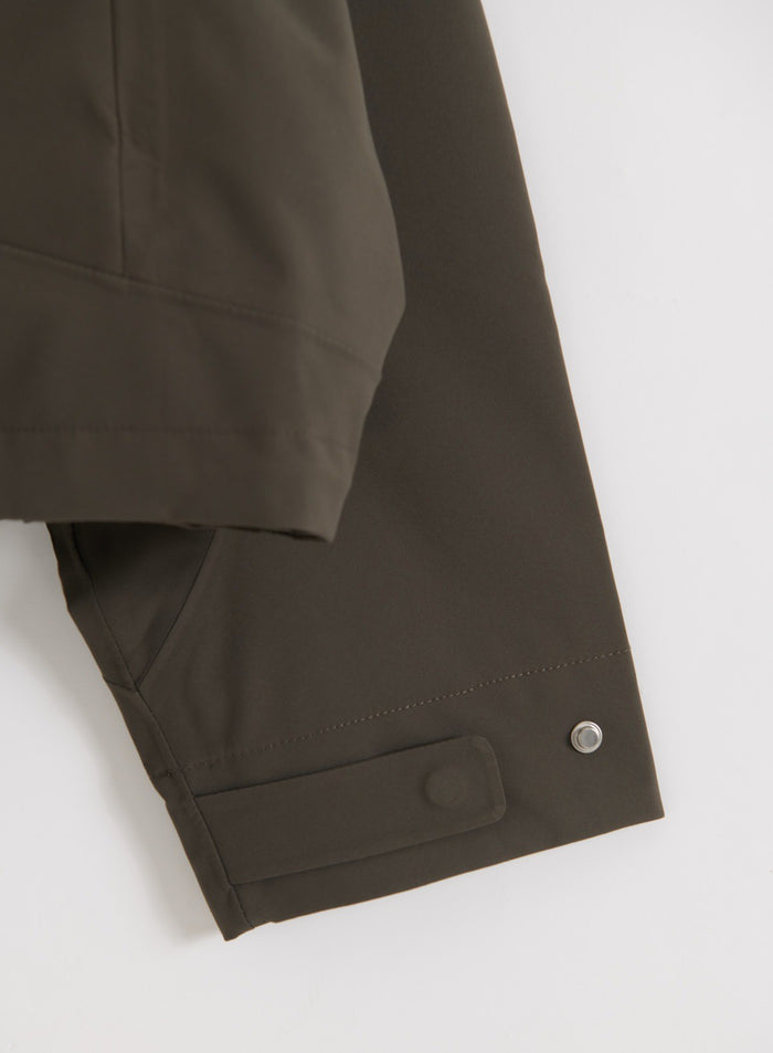Flatlay of Dark Ivy Waterproof Jacket sleeve detail showing button closure