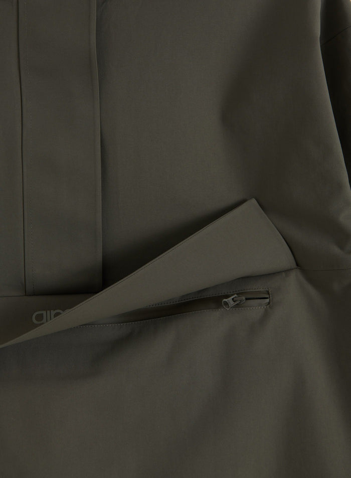 Close-up of the zipped chest pocket and flap on the aim'n dark ivy waterproof oversized anorak
