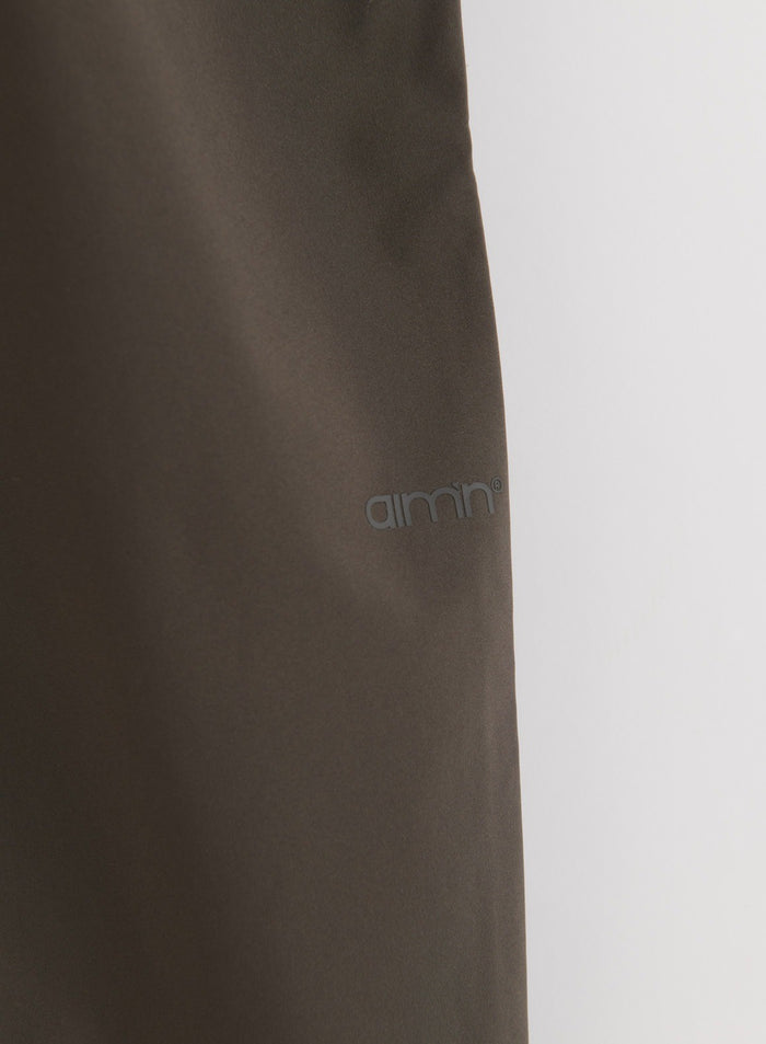 Close-up of Dark Ivy Waterproof Pants fabric with aim'n logo