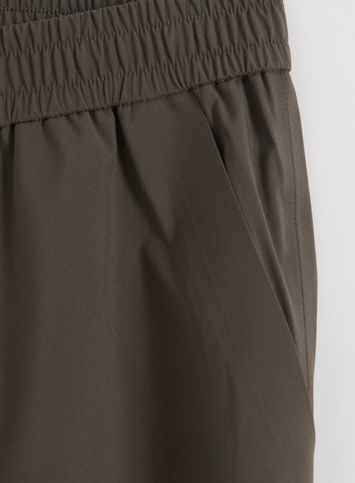 Close-up of dark ivy waterproof pants waistband and hand pocket