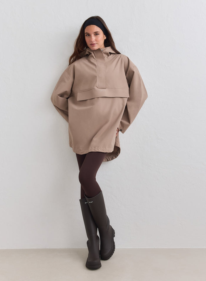 Model wearing Espresso Waterproof Oversized Anorak from aim'n with tall boots [M-178cm]