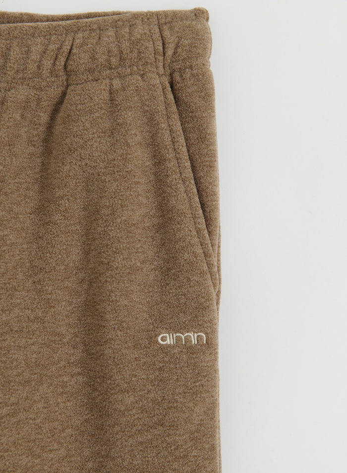 Close-up of the hazelnut fleece pants from aim'n showing the pocket and logo detail