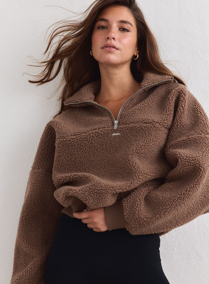 Woman wears a hazelnut brown Pile Half Zip sweater in a soft fleece by aim'n. [xs-178cm]