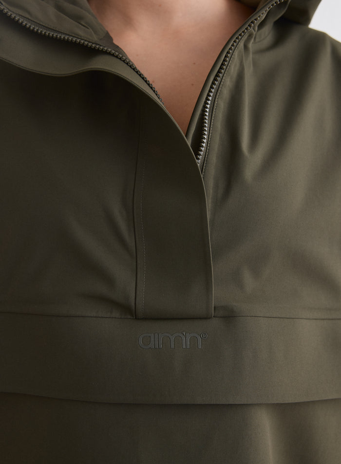 Close-up of the front detailing on the Khaki Waterproof Oversized Anorak featuring the aim'n logo [M-174cm]