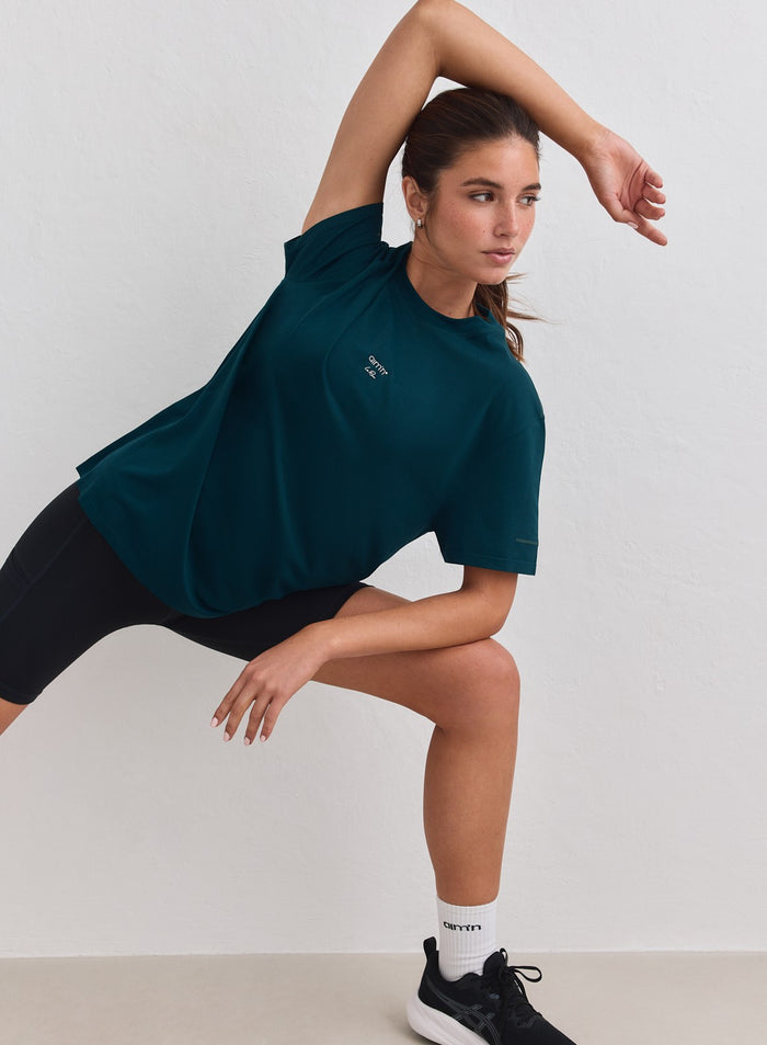 Lagoon teal relaxed-fit aim'n Le Run Seamless Running T-shirt worn by a woman in a side lunge [M-178cm]