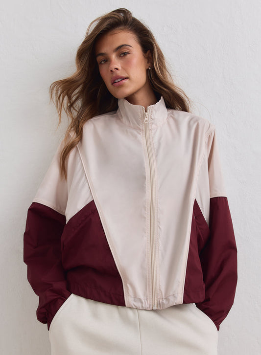 Merlot and cream color-blocked aim'n windproof tracksuit jacket featuring a loose fit and high collar.