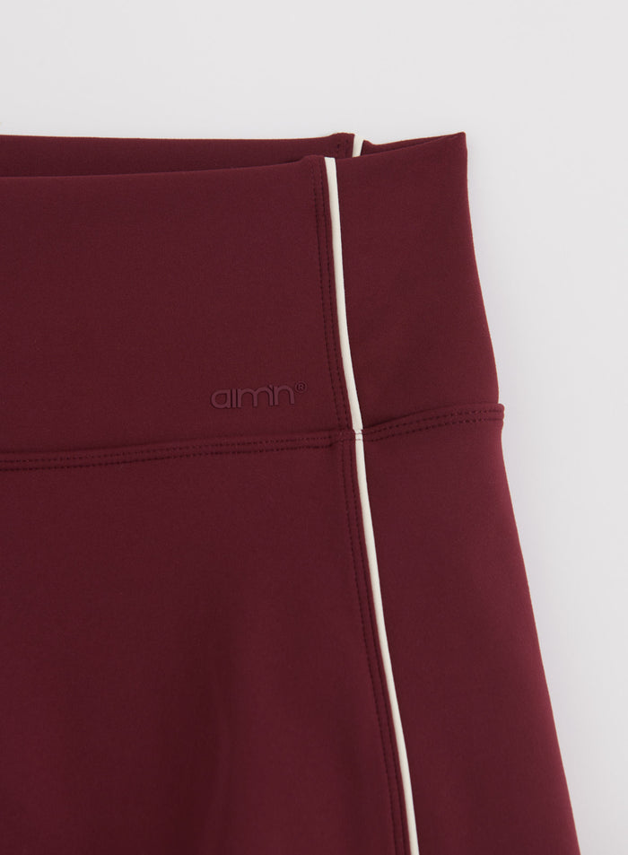 Merlot red Sense Contrast Skort by aim'n with white contrast piping and an embossed logo.