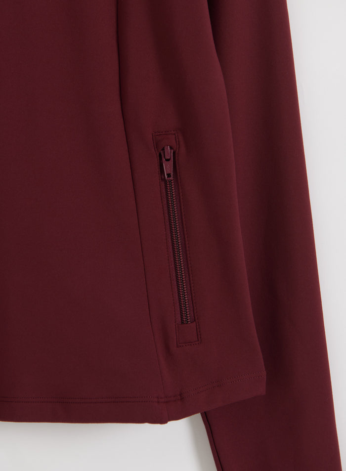 Close-up of a zippered hand pocket on the merlot aim'n Sense Zip Jacket made from peachy soft fabric.