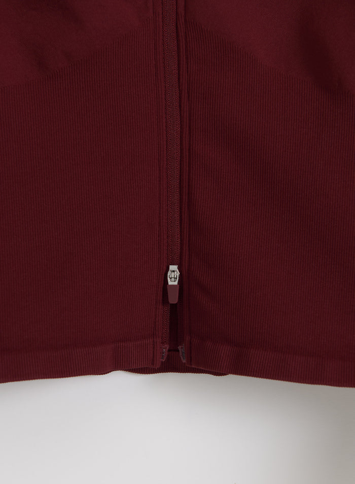 Merlot aim'n Shape Seamless Zip Jacket detail featuring a full-length zipper and contouring ribbed fabric.