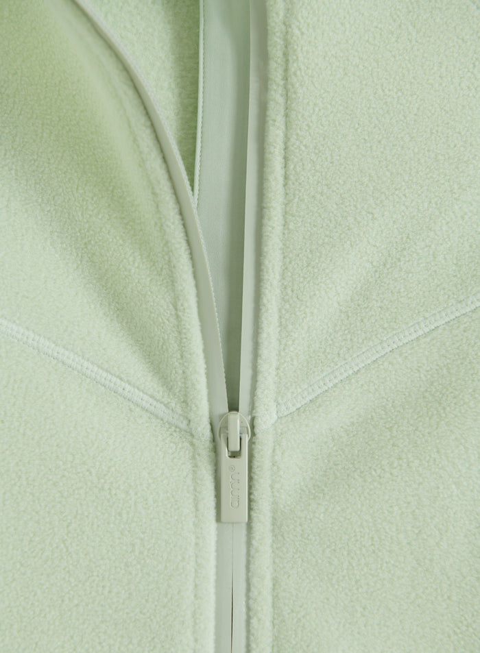 Close-up of the zipper detail on the pistachio stretch fleece zip jacket