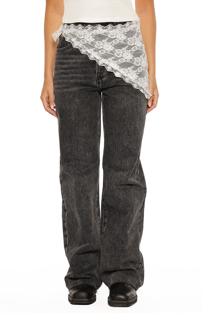 White lace triangle scarf tied at the left hip, showing the scalloped edge and floral pattern