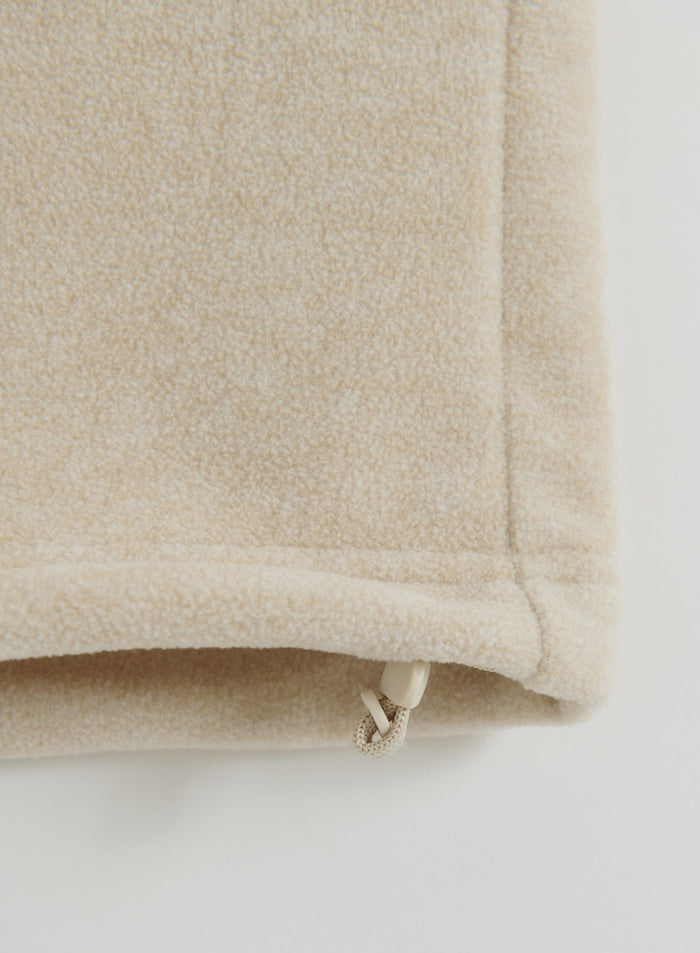 Close-up of the sand fleece pants hem with an adjustable drawcord detail