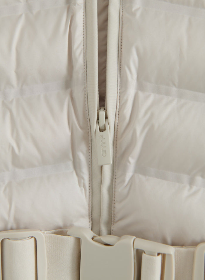 Close-up of the sand Hybrid Jacket showing padded fabric, front zipper and buckle detail