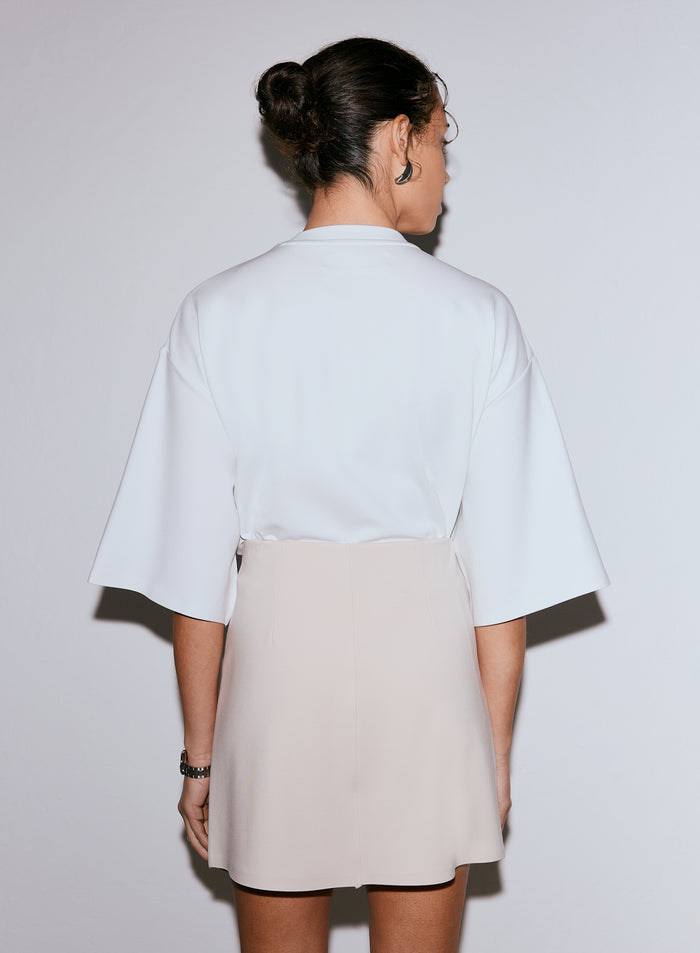 Back view of model wearing a sand Luxe Mini Skort with a white top [36-170CM]