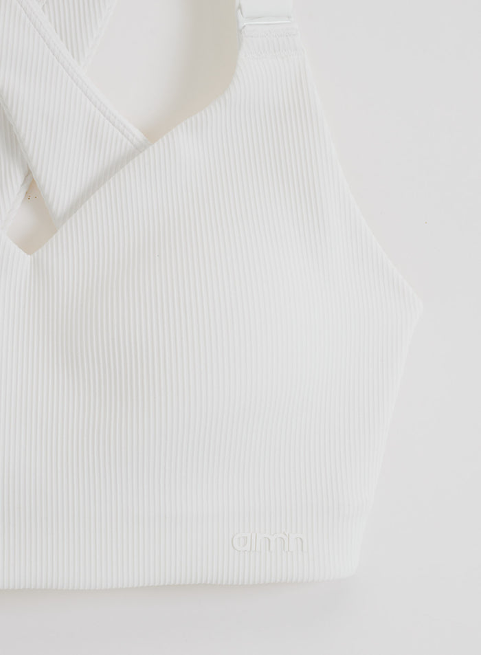 White ribbed performance support bra by aim'n featuring a V-neck and tonal logo detail.