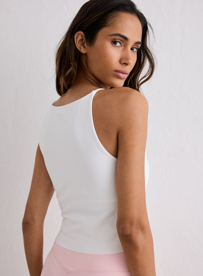 A woman wearing a White Sense Halter Bralette from aim'n looking over her shoulder [XS-170cm]