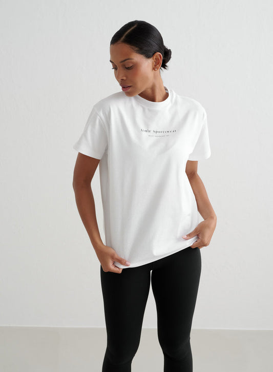 White oversized Serif Boyfriend T-shirt by aim'n featuring a small black chest logo and short sleeves.