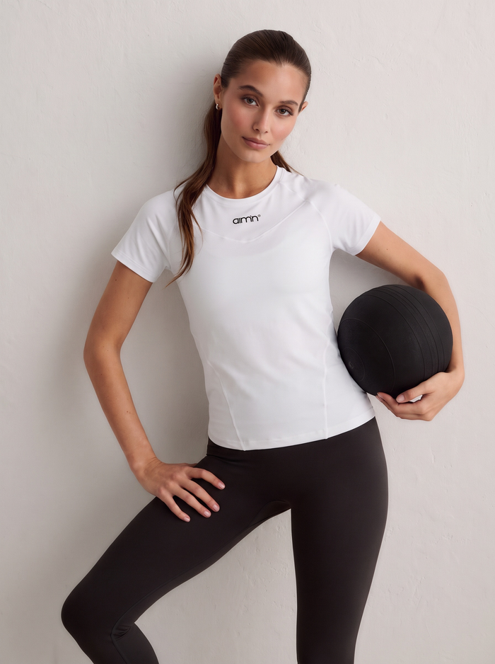 Model wearing a white Soft Basic Short Sleeve top holding a black ball [S-174 cm]