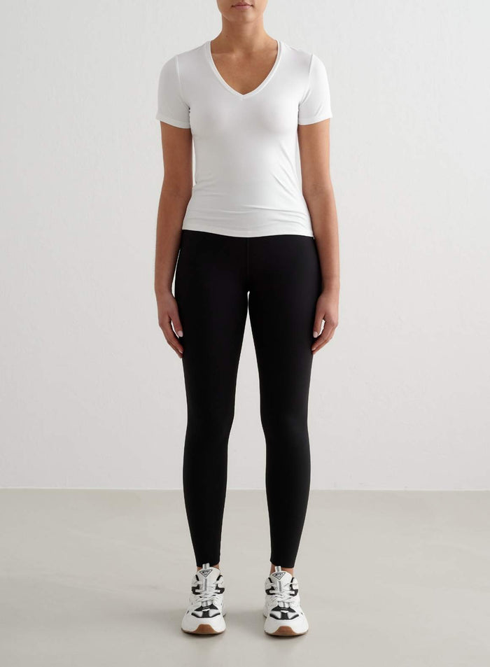 White tight-fit Soft Basic V-neck Short Sleeve top by aim'n styled with black leggings.