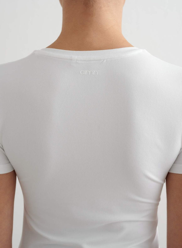 White Soft Basic short-sleeve top featuring a subtle aim'n logo on the back functional fabric.